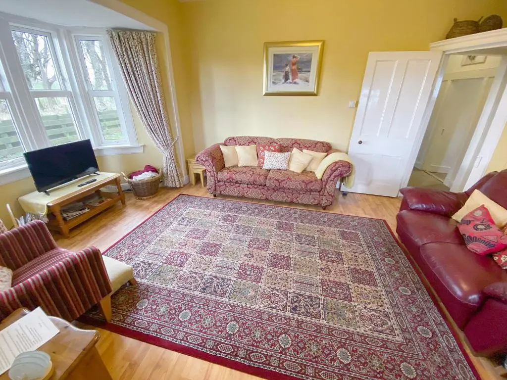 a living room with a couch and a rug at The Gate Lodge in Latheron