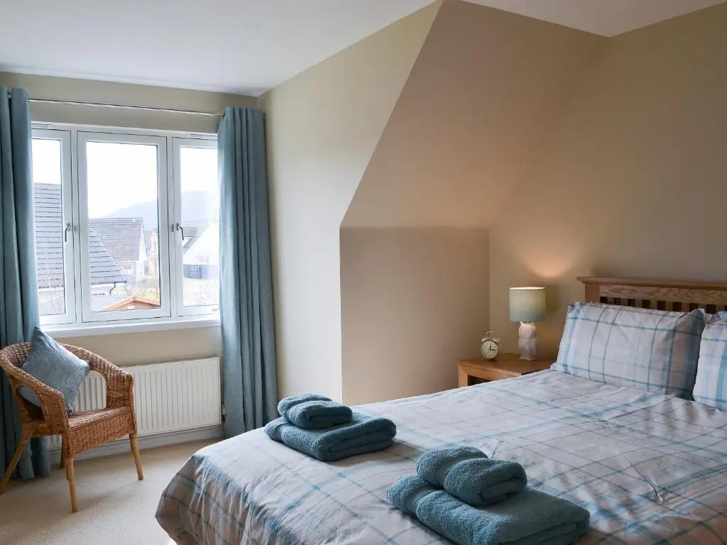 a bedroom with a bed with blue towels on it at Stags Neuk in Aviemore