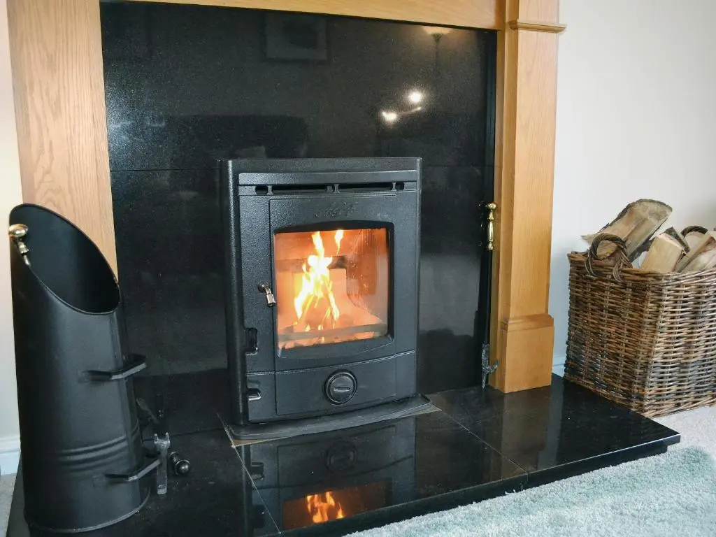 a stove in a room with a fire in it at Stags Neuk in Aviemore