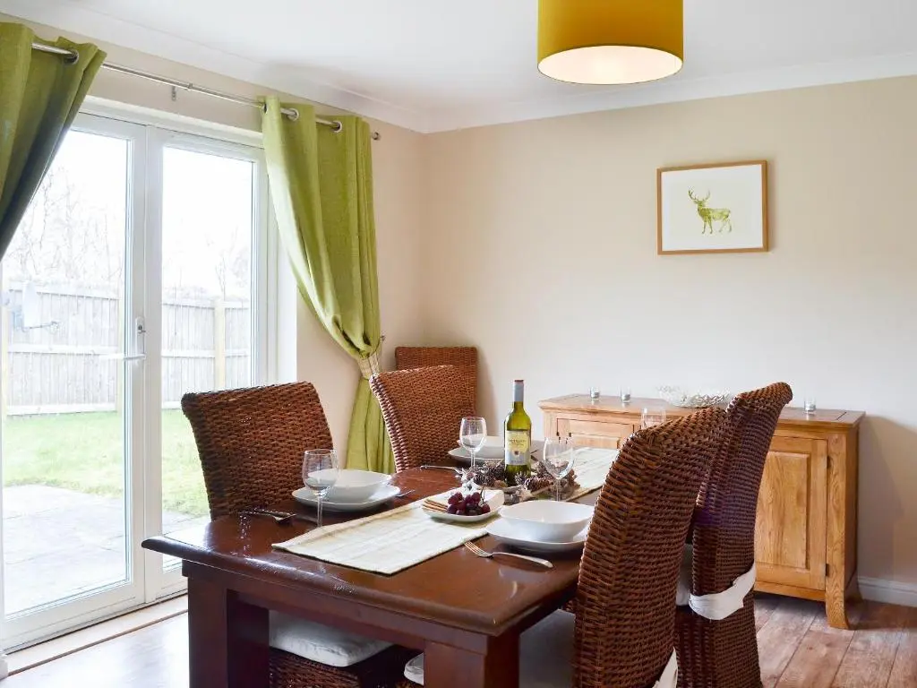 a dining room with a wooden table and chairs at Stags Neuk in Aviemore