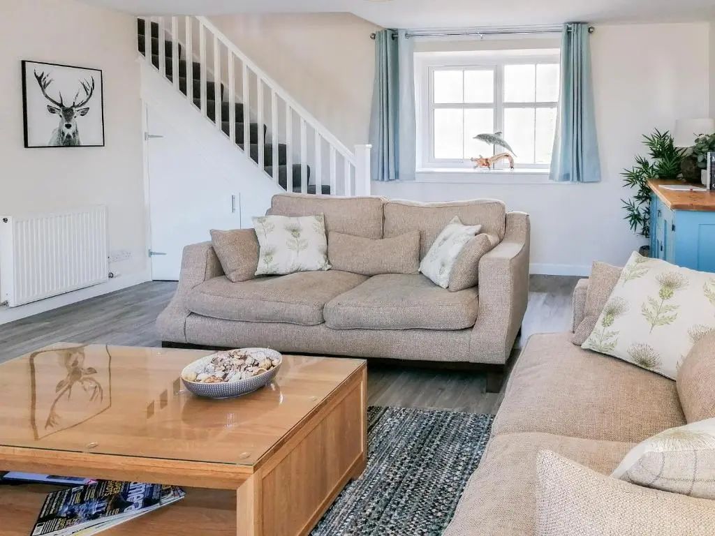 a living room with a couch and a coffee table at Rosslyn Cottage in Portmahomack