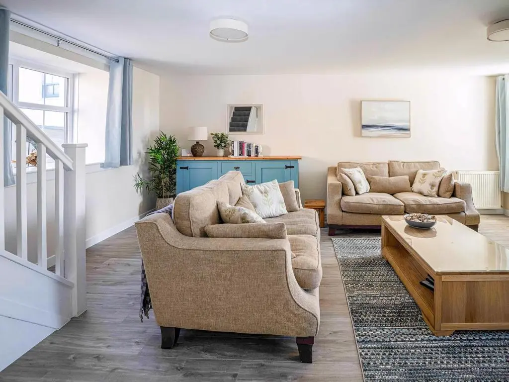 a living room with two couches and a table at Rosslyn Cottage in Portmahomack