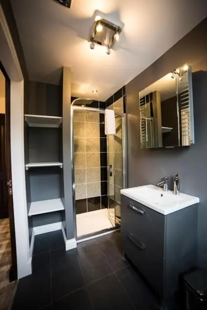 a bathroom with a shower and a sink and a mirror at Whitehouse B&B in Fort Augustus