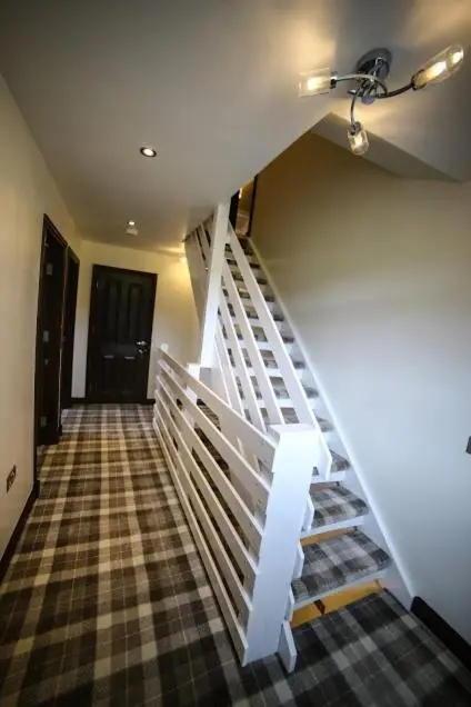 a staircase in a house with a white stair case at Whitehouse B&B in Fort Augustus