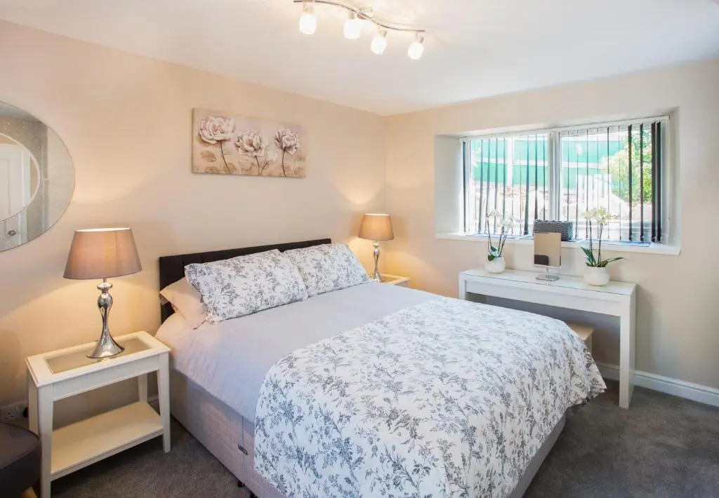 a bedroom with a bed and two night stands at Shore View Cottage in Inverness