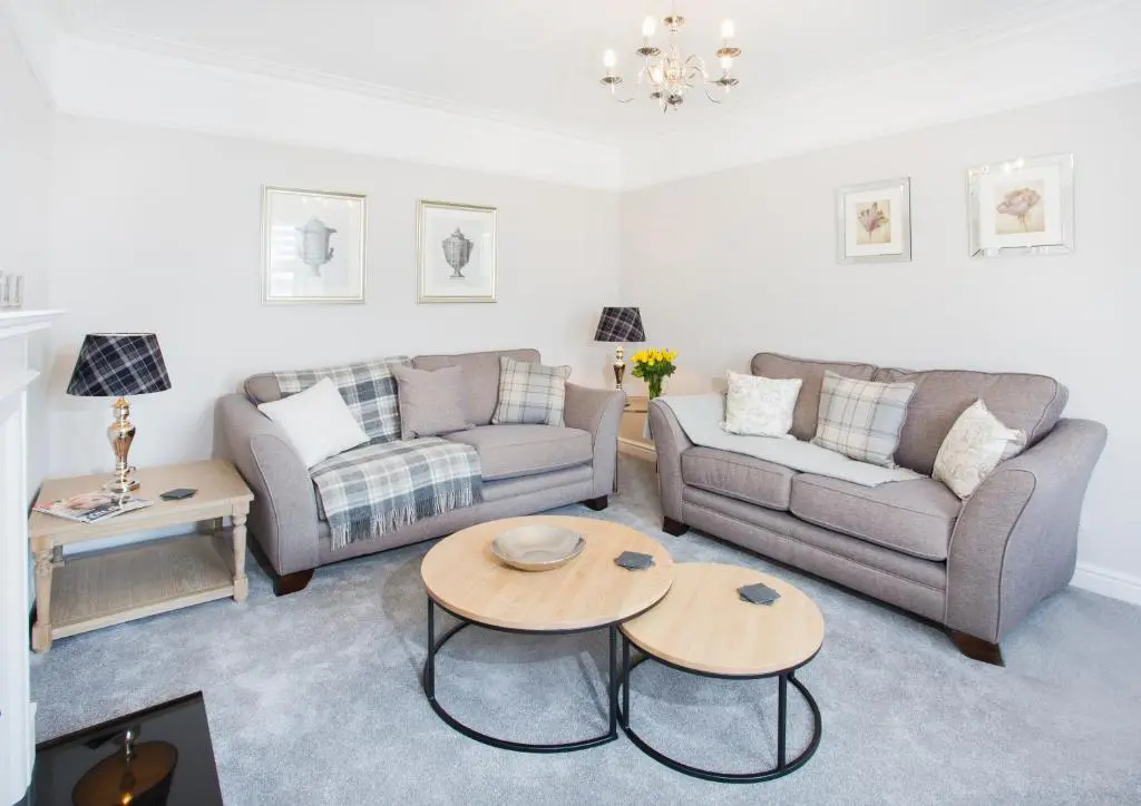 a living room with two couches and a table at Shore View Cottage in Inverness