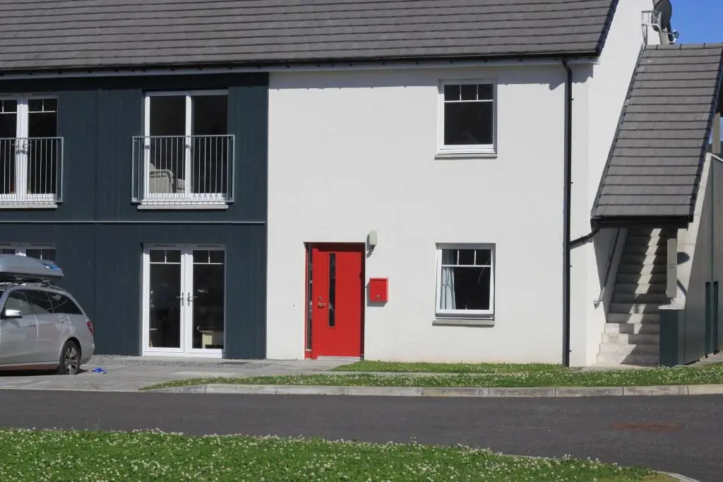 a white and red house with a red door at Ventoux in Aviemore