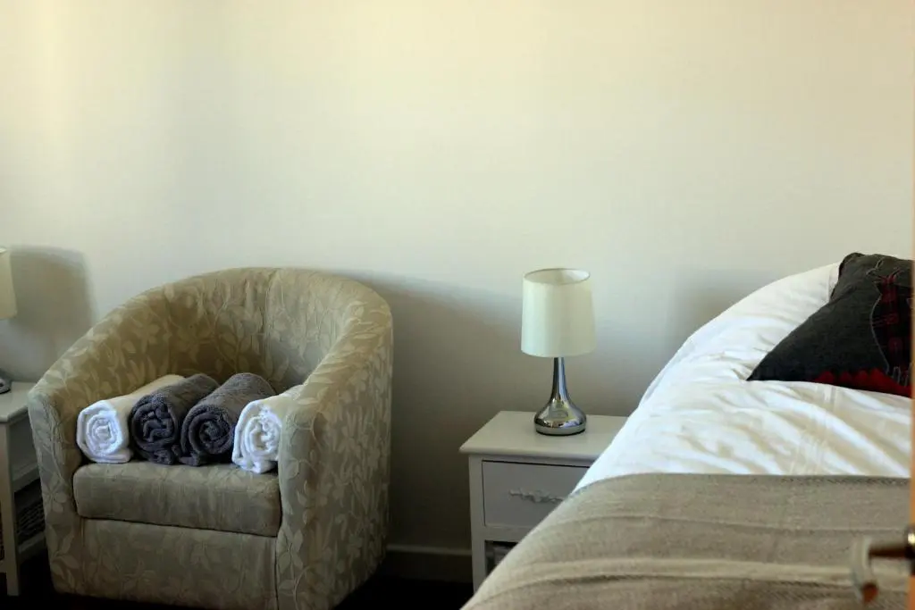 a bedroom with a chair next to a bed at Ventoux in Aviemore