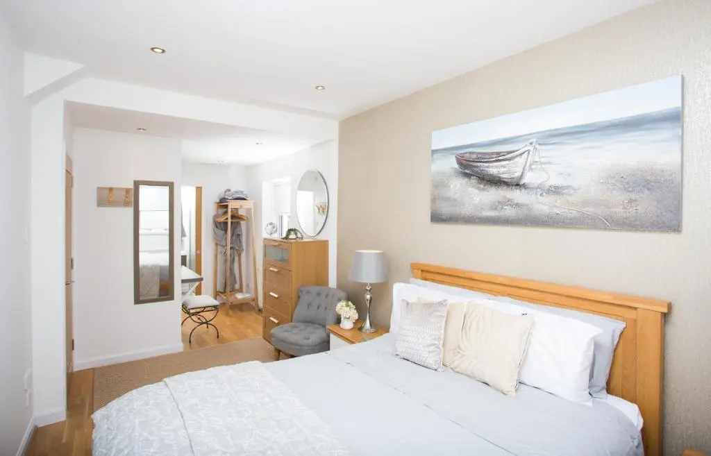 a bedroom with a bed and a painting of a boat at Fishermans in Inverness