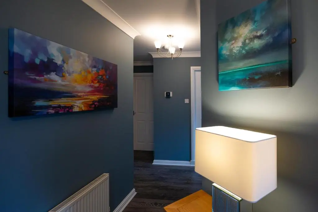 a hallway with a painting on the wall and a light at Tigh na Lochan in Aviemore