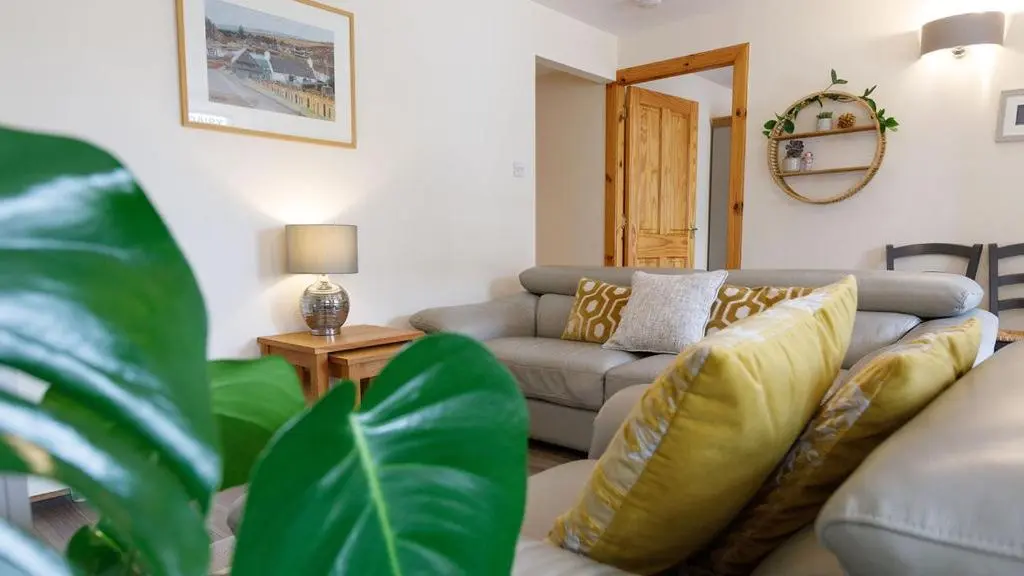 a living room with a couch and a table at The Old Dairy in Lairg