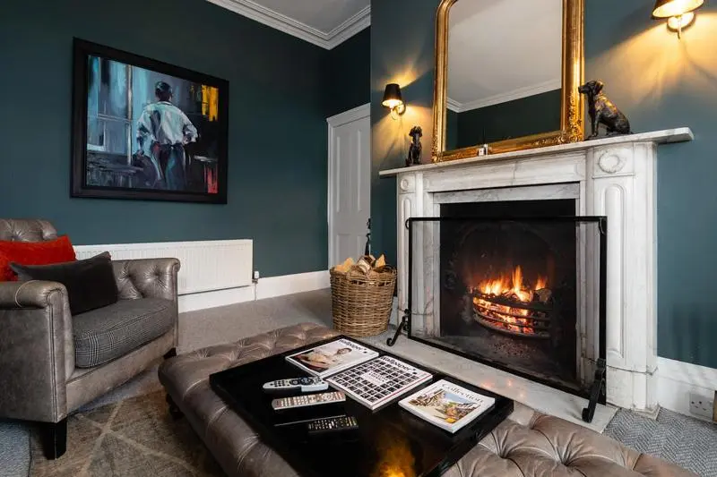 a living room with a couch and a fireplace at The Old Manse of Blair, Boutique Hotel & Michelin Restaurant in Blair Atholl