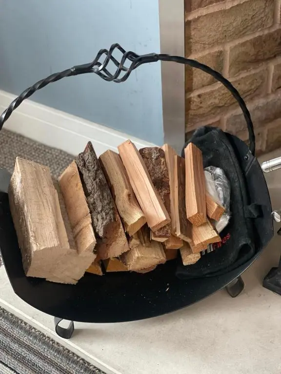 a pile of wood in a black bowl at Seaforth Cottage -Dog friendly, Historical Fishertown, central location in Nairn