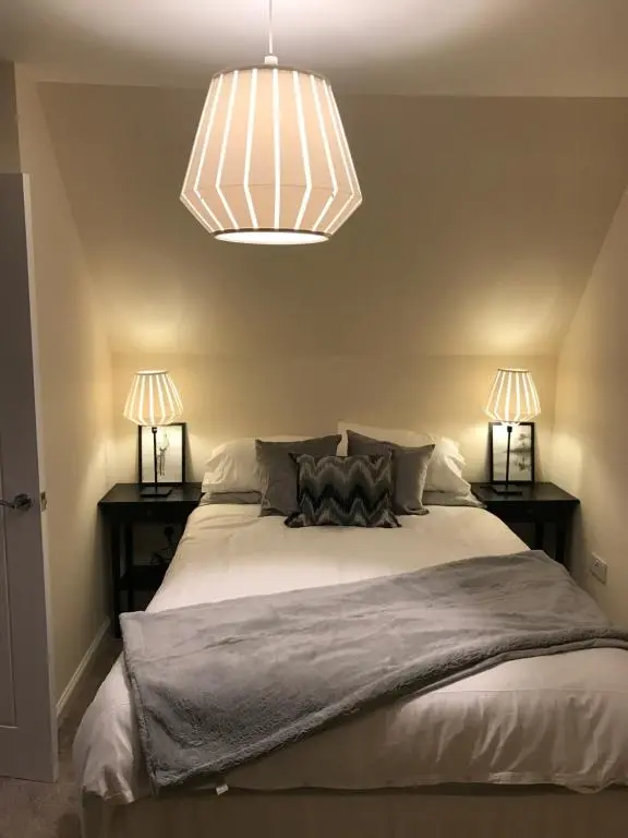 a bedroom with a large bed with two lamps at View Cottage in Inverness