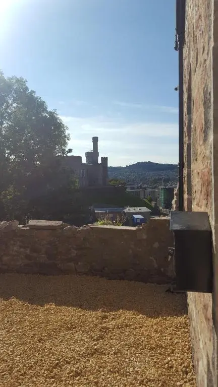 a stone wall with a view of a castle at View Cottage in Inverness