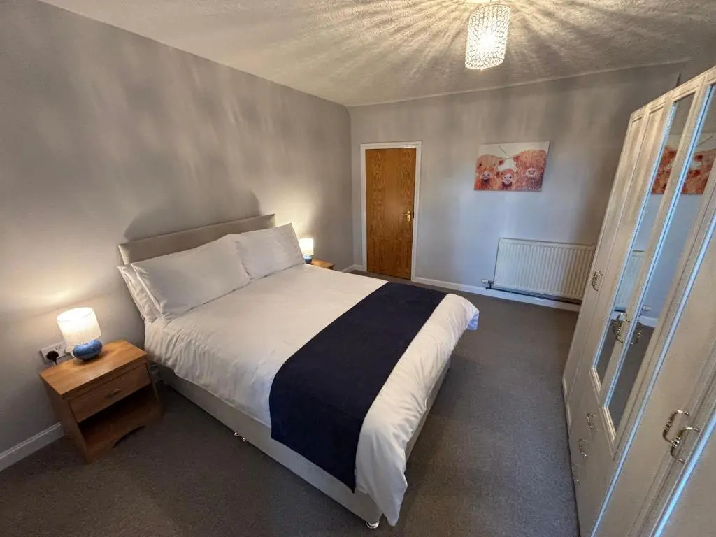 a bedroom with a large bed and a door at The Coffee Pot accommodation in Dufftown