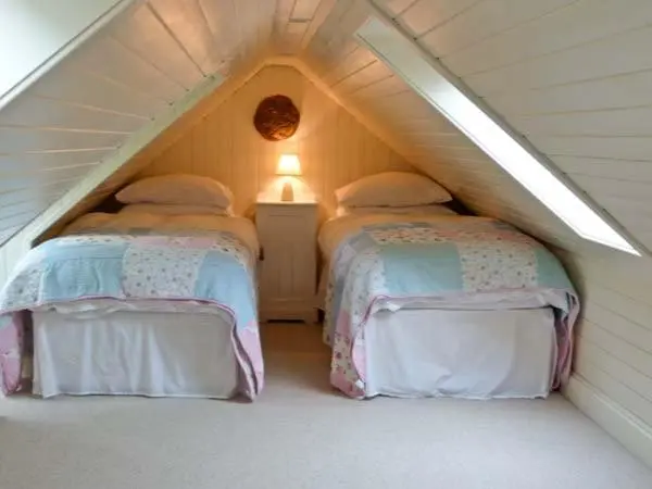 a room with two beds in a attic at Easter Urray Farmhouse in Muir of Ord