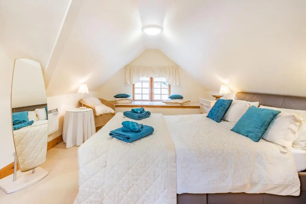a bedroom with a bed with blue towels on it at Dunstaffnage Cottage in Grantown on Spey