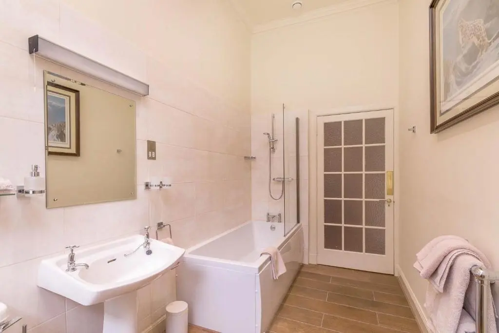 a white bathroom with a tub and a sink at Blervie House in Forres