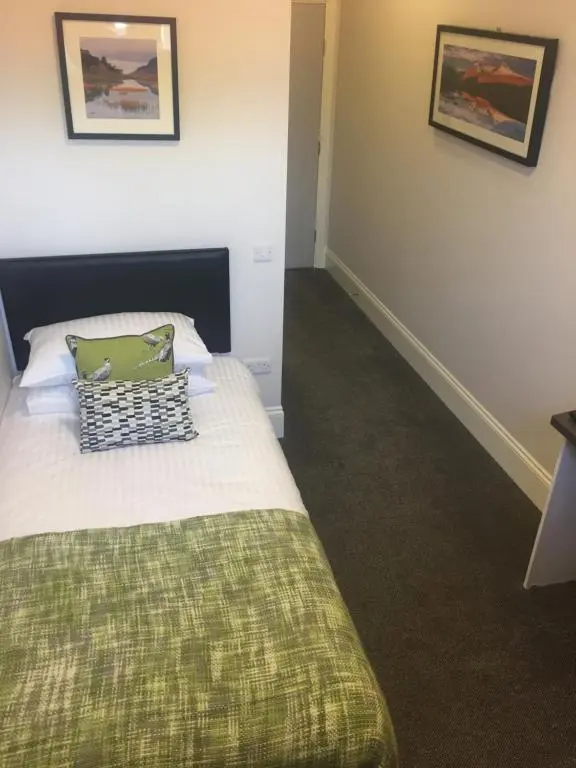 a bedroom with a bed with a green blanket at The Sidings Inverurie in Inverurie