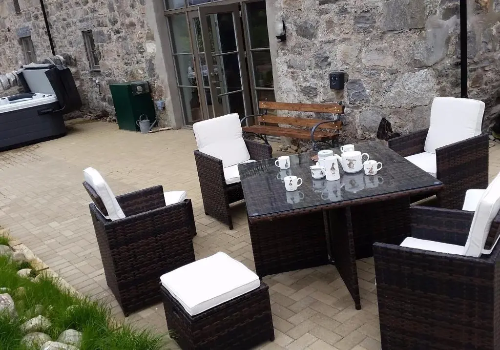 a patio with a table and chairs and a television at Osprey Lodge in Kingussie