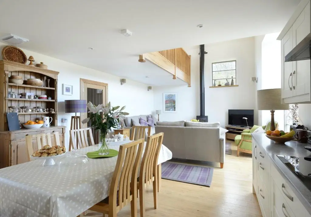 a kitchen and living room with a table and chairs at Osprey Lodge in Kingussie