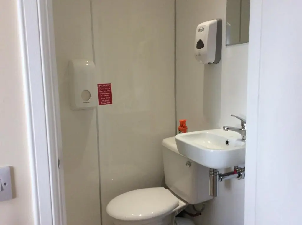 a small bathroom with a toilet and a sink at Rudan Guest House AB53 6UQ in New Deer