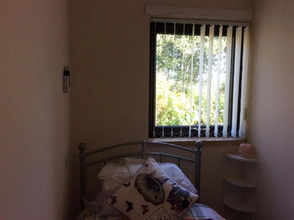 a small bedroom with a bed with a window at Rudan Guest House AB53 6UQ in New Deer