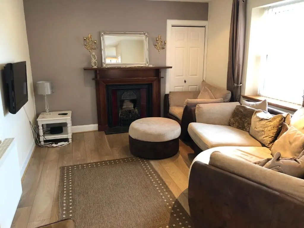 a living room with a couch and a fireplace at Rose Cottage in Inverness