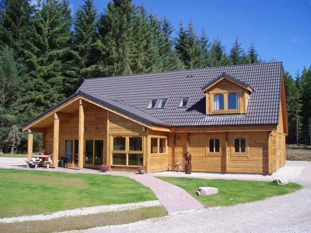 a log cabin with a gambrel roof at Badaguish forest lodges and camping pods in Aviemore