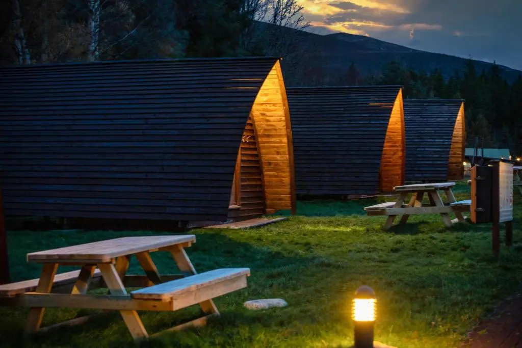 a couple of picnic tables in front of a building at Badaguish forest lodges and camping pods in Aviemore