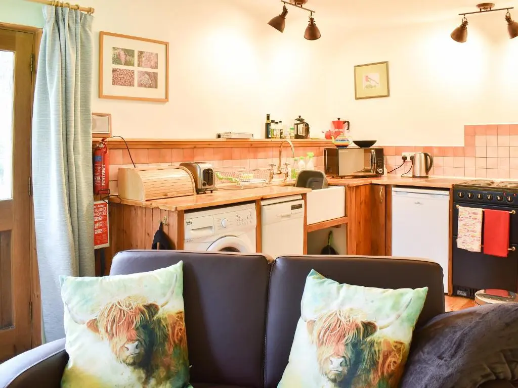 a living room with a couch and a kitchen at St Orans in Rafford