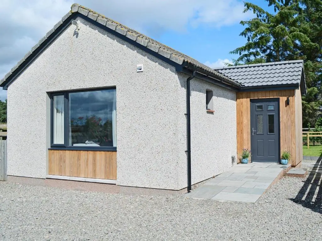 a small white building with a window and a door at Barn Owl Cottage in Inver