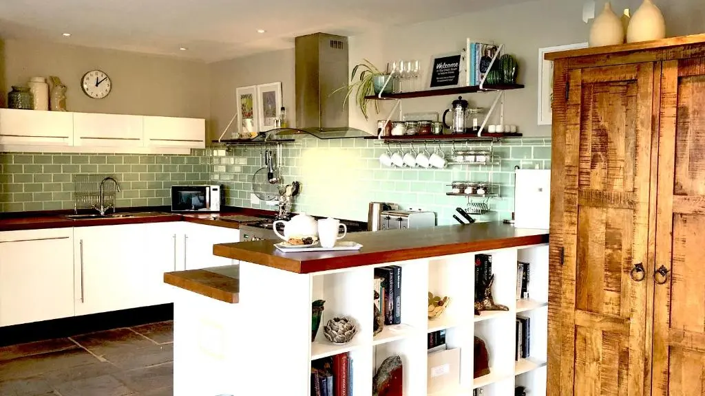 a kitchen with white cabinets and a counter top at Coach House at Soilzarie in Blairgowrie