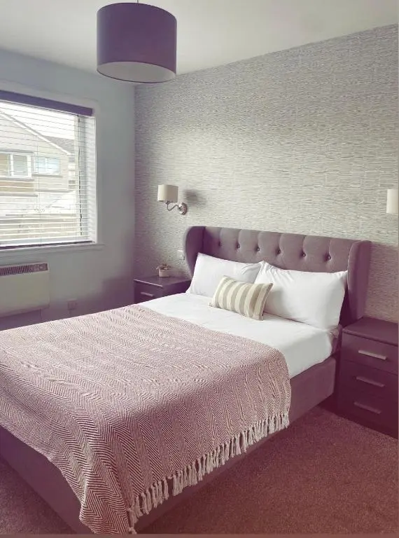 a bedroom with a large bed and a window at Malva - Modern 2 Bedroom Bungalow in Wick Sleeps 4 with private parking - NC500 Route in Wick