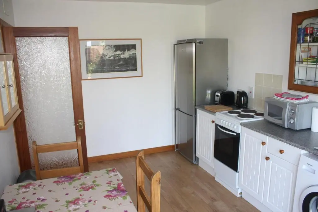 a kitchen with a stove and a refrigerator at Inver bay apartment in Tain