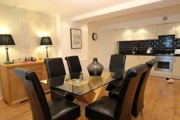 a dining room with a glass table and chairs at Lovat Loch Ness Apartment with private roof terrace in Fort Augustus