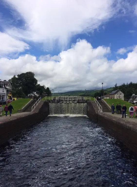 a water canal with people standing around it at Lovat Loch Ness Apartment with private roof terrace in Fort Augustus