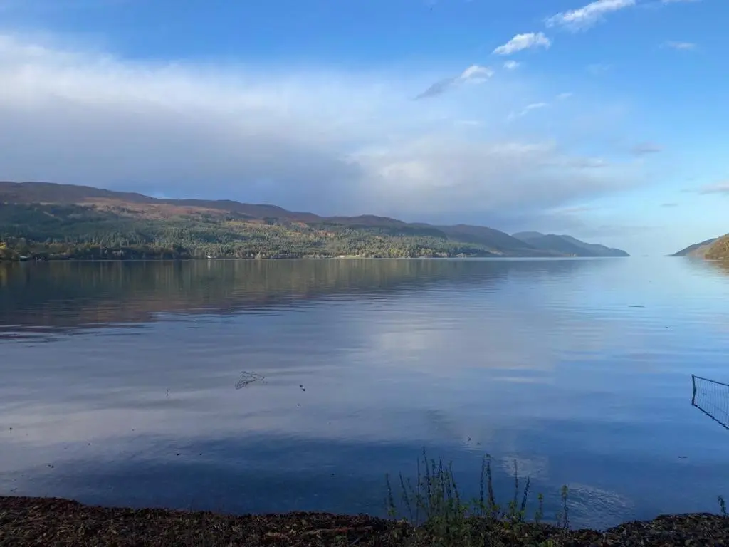 a large body of water with mountains in the background at Lovat Loch Ness Apartment with private roof terrace in Fort Augustus
