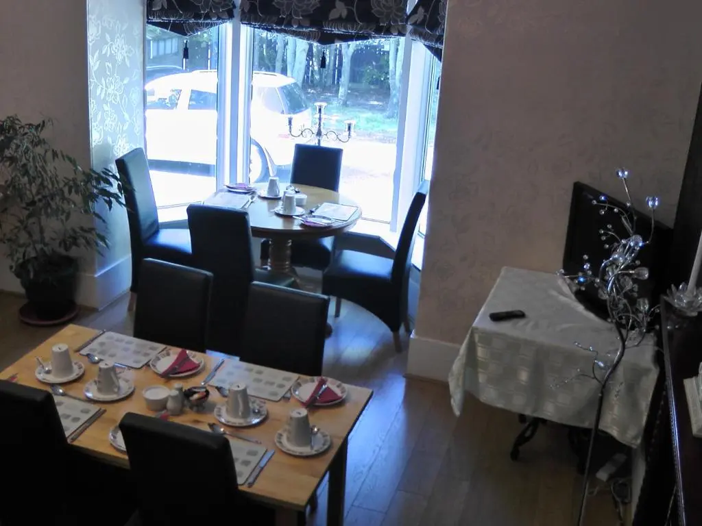 a dining room with a table and a table and chairs at Station View Guest House in Dyce