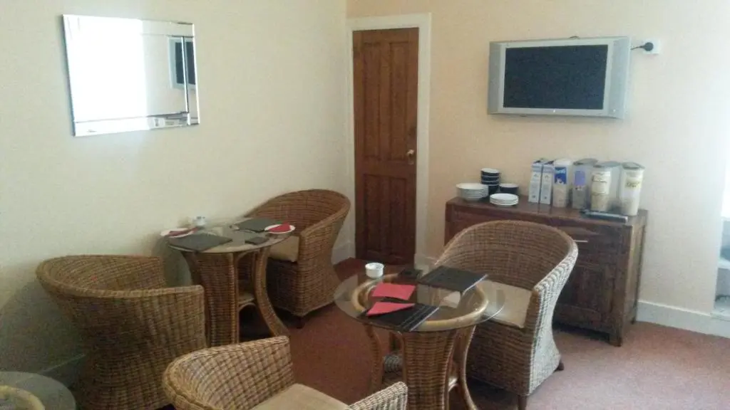 a hotel room with chairs and a table and a television at Beeches Guest House in Dyce