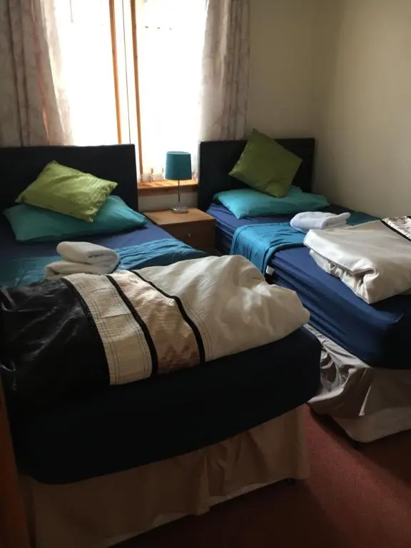 a room with two beds and a window at Christiesholidayhomes in Aviemore