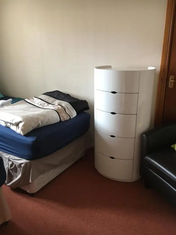 a bedroom with a bed and a white dresser at Christiesholidayhomes in Aviemore