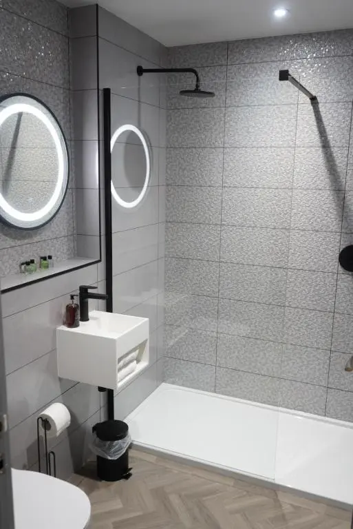 a bathroom with a shower and a sink and a mirror at The Knowes Hotel & Restaurant in Macduff