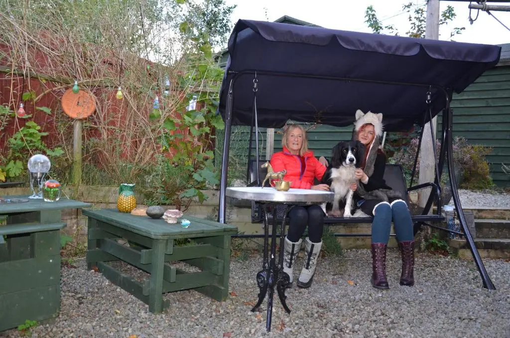 two women sitting on a table with a dog at Averon House in Inverness