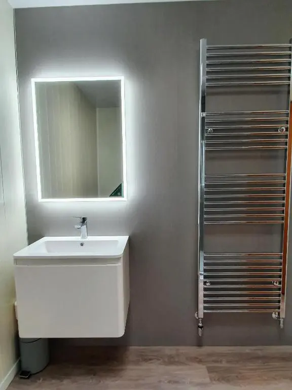 a bathroom with a white sink and a mirror at Doric House in Inverness