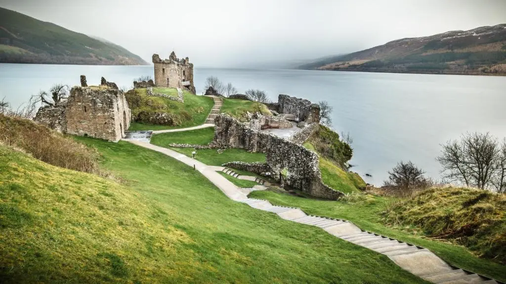 a castle on a hill next to a body of water at Farraline Court in Inverness