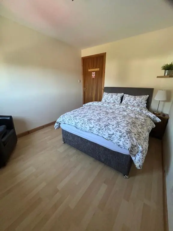 a bedroom with a bed and a wooden floor at No 52 - Apartment with Lounge and Dining Area - No kitchen in Ullapool