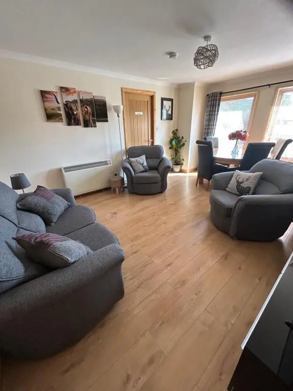 a large living room with two couches and chairs at No 52 - Apartment with Lounge and Dining Area - No kitchen in Ullapool