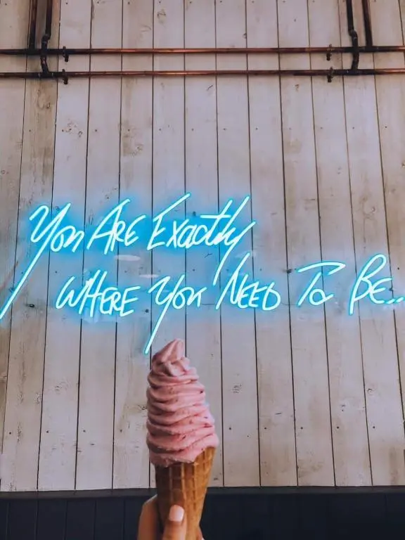a person holding an ice cream cone in front of a sign at The Lodges @ Barra Castle in Inverurie